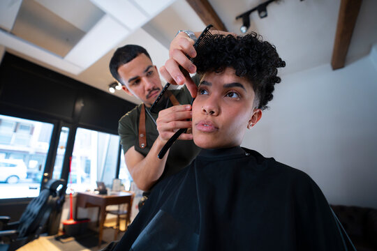 Client receiving a haircut in a barbershop setting