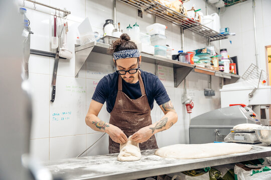 Baker shaping bread dough in professional bakery