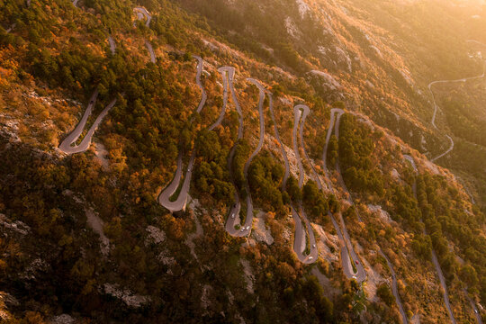 Winding Road Through Mountains During Golden Hour in Autumn