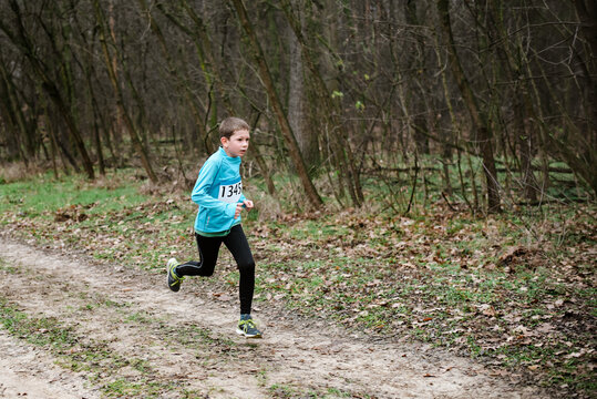 Boy running in a forest. He is taking part in a running race. 