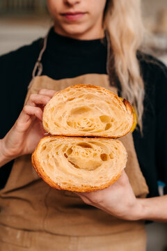 Baker Shows Inside of Fresh Croissant in Bakery 