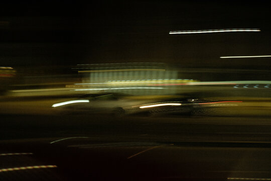 Night street with motion blur from passing car