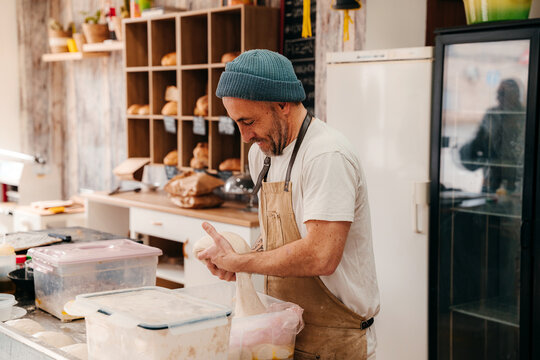 Baker Prepares Dough in a Busy Bakery Kitchen 