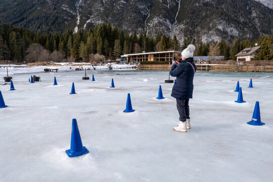 Woman Taking Photo on Frozen Lake During Winter Trip