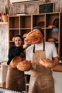 Bakers Hold Fresh Bread at a Local Bakery in the Morning