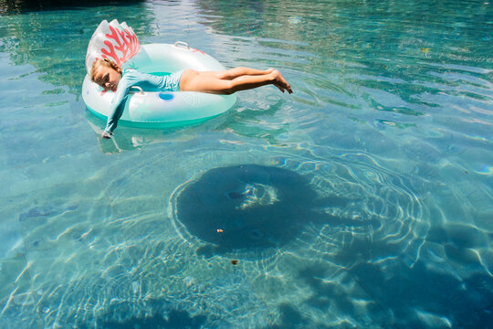 Relaxed Child Floating on Pool Float