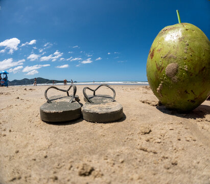 Footwear and Fruit on the Sand Near the Ocean at Midday
