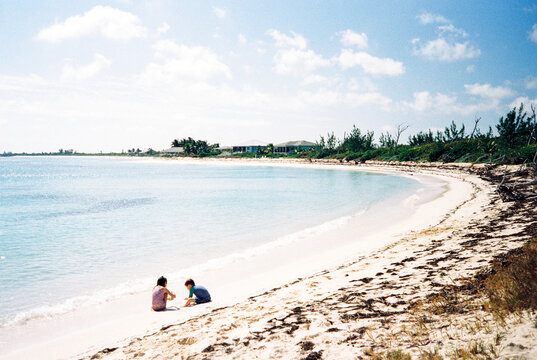 Children play in the sand on a beach in the Bahamas