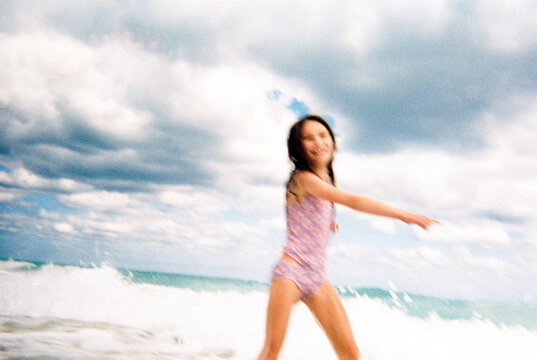 Candid blurry happy film portrait of child playing on beach