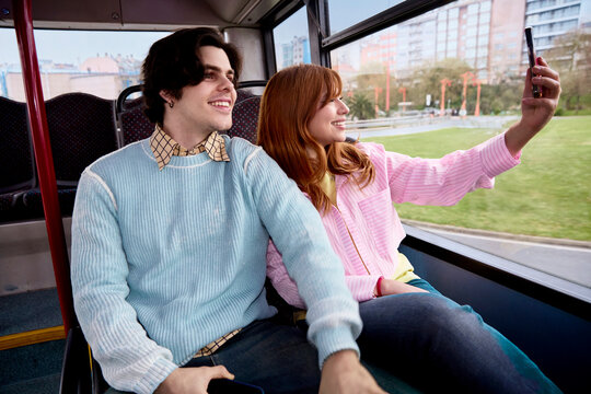 Couple taking photos inside city bus during urban travel