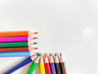 Fototapeta premium Colorful pencils corner arrangement with copy space white background education creativity