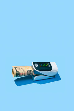 a pulse oximeter grips a rolled banknote