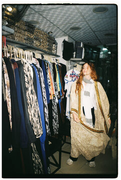 Woman Browsing Clothes in a Shop Located in a Busy Market Area