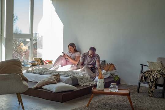 Interracial couple relaxing at home on a bed