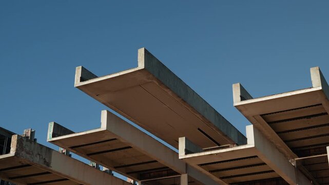 Close view of geometric concrete architecture at an abandoned resort complex with minimalist brutalist design and clear blue sky in Croatia.
