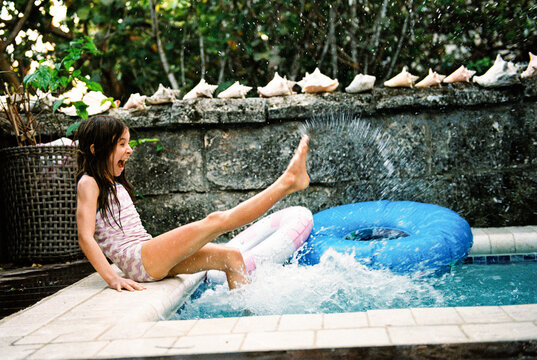 Candid vacation moment of happy child splashing in pool