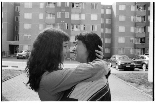 Couple Embracing Outside Apartment Buildings