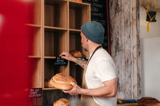 Baker Organizes Bread Display in Local Bakery