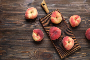 Board with sweet fig peaches on wooden background