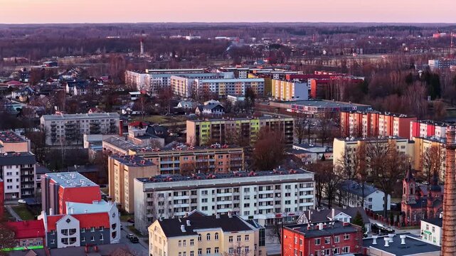 Post soviet residential apartment blocks and houses in a small town during a colorful sunset