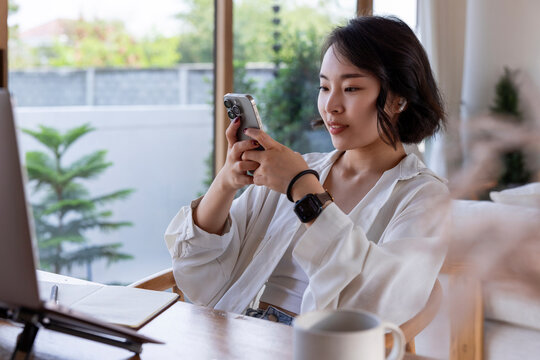 Woman using phone while working from home.