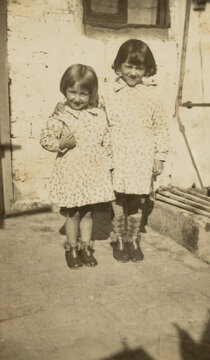 Two young sisters smiling in vintage 1950s style