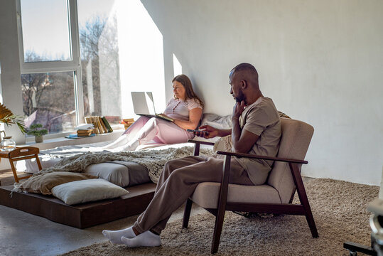 Interracial couple relaxing and working at home