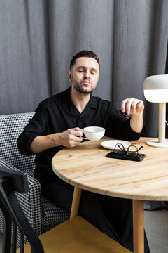 A man with a cup at the table.