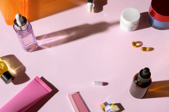 Beauty Products and Medications on Pink Table with Copy Space for Text