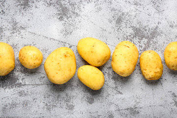 Raw baby potatoes on grey background