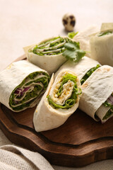 Wooden board of tasty lavash rolls with onion, egg and greens on light background