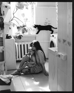 Mother and child spend time together in a bathroom near a window