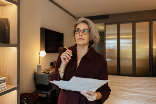 Professional holding papers planning strategy in home office