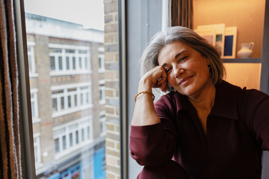 Senior woman enjoying quiet moment watching urban view