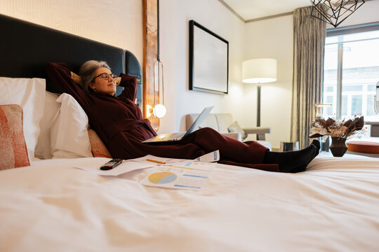 Business traveler relaxing after working on laptop in hotel room
