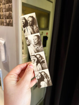 B&W Photo Booth Strip of Two Women Held Outside the Machine
