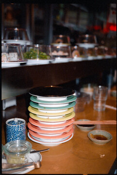 Stack of Colorful Coded Plated at Sushi Train Restaurant 