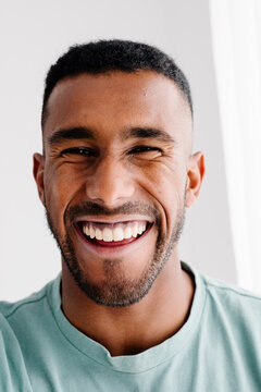Close up portrait captures a cheerful modern man facing the camera