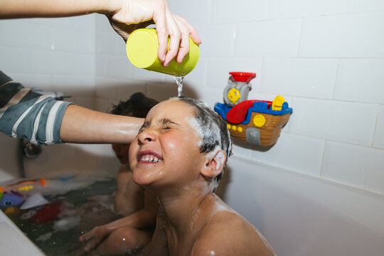 Mother rinsing child's hair during bath time