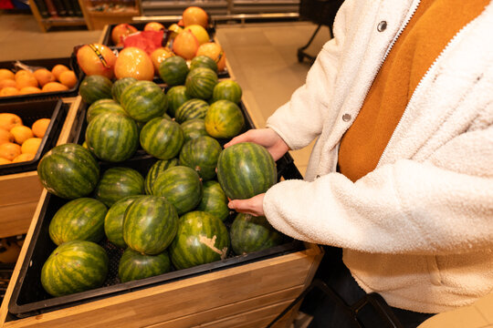 Woman Picking Watermelon at Grocery Store Produce Section