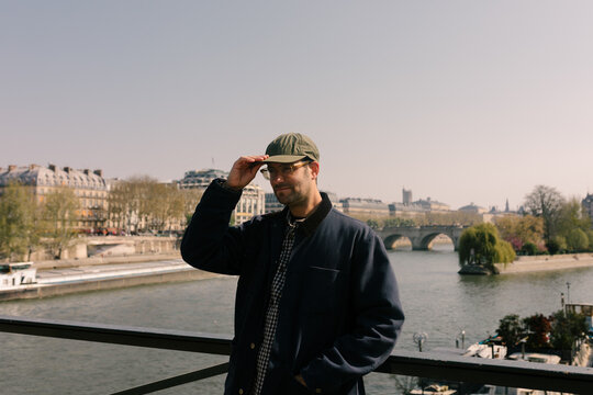 Medium-shot portrait of man on a bridge over the Seine River