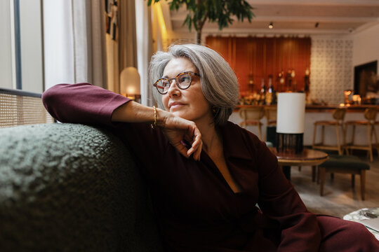 Thoughtful senior woman resting on a comfortable sofa