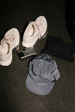 Flat lay of sneakers, a film camera, a wine bottle and a cap