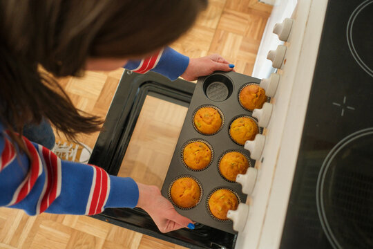 Checking muffins while baking in oven