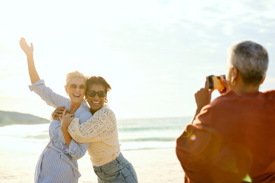 Friends taking photos on the Beach in Sunny Weather