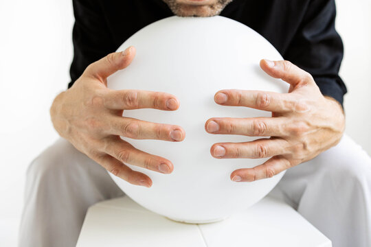 Man holds sphere in minimalist setting