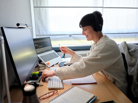 Woman working remotely at home office desk smiling