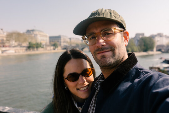 Selfie of a couple of tourists enjoying a walk along the Seine River