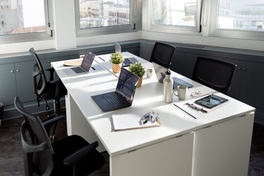 Modern coworking office with laptops and equipment on desks