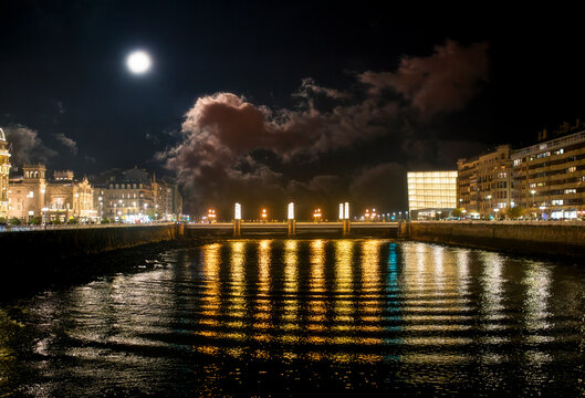 Moonlit European City bridge With Golden Light Reflections at night